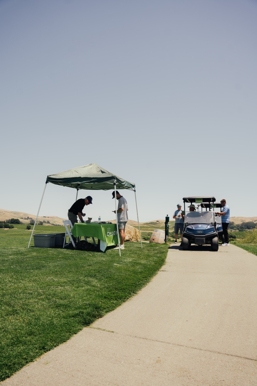 Mentor assisting young golfer with proper swing technique on fairway